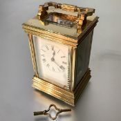 A French brass-cased carriage clock, c. 1900, the case with stepped base and shaped part-reeded