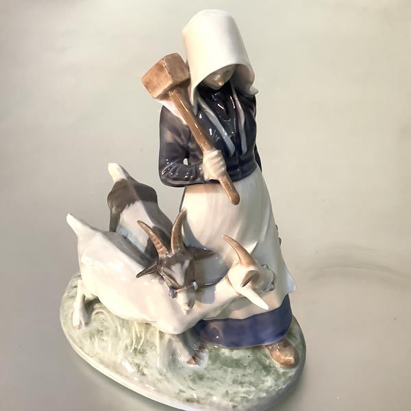 A Royal Copenhagen porcelain group of a girl goatherd and goats, model no. 694. Height 24cm