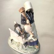 A Royal Copenhagen porcelain group of a girl goatherd and goats, model no. 694. Height 24cm