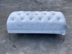 A contemporary footstool, upholstered in an overstuffed buttoned grey crushed velvet fabric,