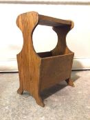 A mid to late 20thc. oak magazine stand, the tray top above two division magazine well to base,