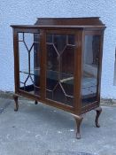 An Edwardian mahogany display cabinet, the shaped raised back over a rectangular moulded top, two