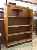 A modern oak open bookcase, the raised back with egg and dart moulding over open shelf and two