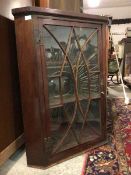 An early 19thc George III inlaid mahogany wall hanging corner cupboard, the single astragal glazed