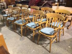 A set of ten modern beech dining chairs, all carvers, with spindle backs on turned supports united