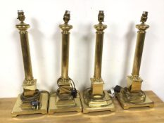A group of four brass table lamps in the form of columns with square bases (each: 54cm)