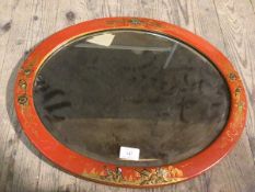 An early 20thc oval mirror, the glass within a red lacquered frame, with gilt chinoiserie decoration