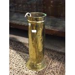 An early 20thc brass cylindrical stick stand, the base with hammered boteh motif, on a splay base (