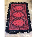 A modern rug, the red field with three C scroll cartouches, within a stylised leaf border, with