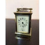 A late 19thc brass alarm carriage clock, the cream enamelled dial with arabic numerals and painted