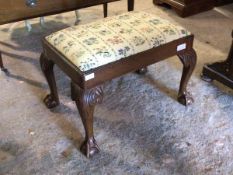 An early 20thc Chippendale style footstool, the drop in floral upholstered seat pad above acanthus