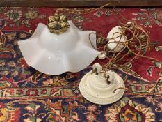 A rise and fall ceiling light fitting with a floral ceramic ceiling rose above a floral brass