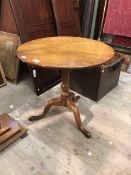 A George III mahogany tripod table, the single plank circular tilt top raised on a ring and baluster