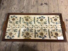 An embroidered foliate design panel within a two handled tray (30cm x 59cm)