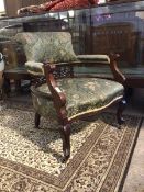 A late Victorian mahogany framed tub shaped open armchair, the back, arms and seat upholstered in