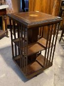 An Edwardian mahogany revolving bookcase, the top centred by an inlaid paterae, and with a satinwood