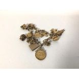 A charm bracelet, on yellow metal chain, markings rubbed, charms to include a 1913 half sovereign,