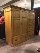 An Edwardian ash combination wardrobe, the projecting cornice above a cupboard and bank of five