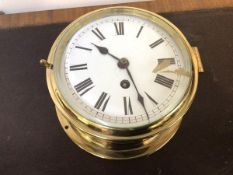 A late 19thc ship's bulkhead type clock, white enamel dial with roman chapter ring in a brass case