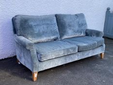 A contemporary two seat sofa by Kingcome Sofas upholstered in a crushed velvet teal fabric, raised