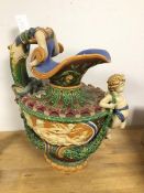 A Minton style majolica ewer with mermaid handle and putti to front above a classically inspired