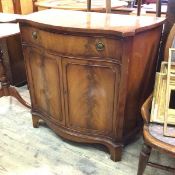 A reproduction side cabinet, the serpentine top above a frieze drawer and two cabinet doors, with