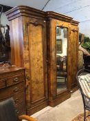 A Victorian figured and burr walnut breakfront triple wardrobe, the central mirrored cupboard door