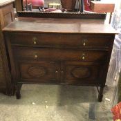A 1920s oak side cabinet, the ledge back with bead moulding above a rectangular top and