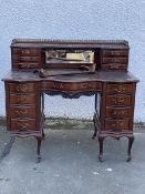 An early 20thc serpentine writing desk of 18thc design, the superstructure with pierced three