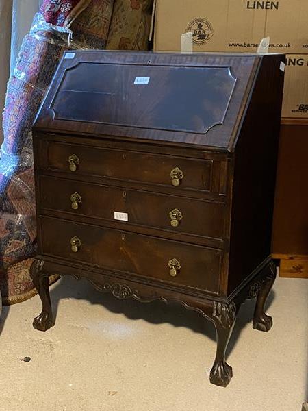 A Georgian style mahogany bureau, the fall front over a fitted interior, above three drawers, on
