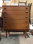 A vintage mid century teak veneer chest of drawers, fitted five graduated drawers, raised on