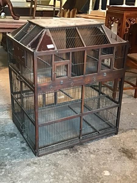 A large decorative Victorian bird cage, the sarcophagus shaped top with red and blue coloured