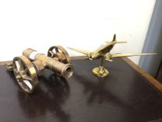 A 20thc cast brass model of a propeller driven aeroplane (h.14cm) together with a cast metal model