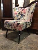 A contemporary bedroom chair, the back and seat upholstered in a colourful floral natural linen