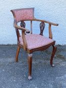 An Edwardian mahogany open armchair in the Arts & Crafts taste, the upholstered crest rail over