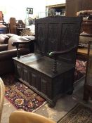 A Victorian carved oak hall settle of an earlier design, the three panel back with lozenge