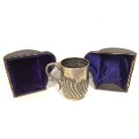 An 1897 London silver Christening mug with gadrooned body, in original case (a/f) (8cm) (124g)