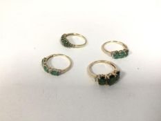 A group of four rings, three marked 375, one marked 10k, all with green stones of varying hues,
