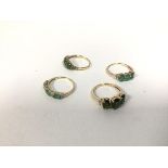 A group of four rings, three marked 375, one marked 10k, all with green stones of varying hues,