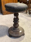 A Victorian walnut rise and fall music stool, the circular upholstered top over a turned stem and