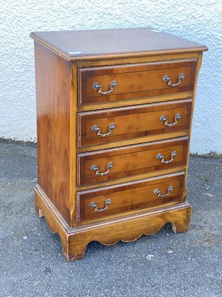 A small Georgian style yew wood chest of drawers, the crossbanded top above four drawers, raised