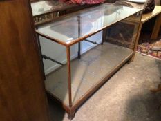 An early 20thc mahogany framed shop display counter with glazed top, sides and front, two panel