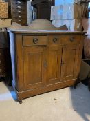 An early 20thc stained pine sideboard, the raised back over three drawers and two cupboards (128cm x