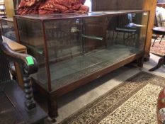 An early 20thc glazed oak shop display counter, the interior fitted two glass adjustable shelves,