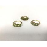 A group of three rings, all marked 375, set peridot in various settings and designs, one set diamond