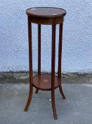 An Edwardian mahogany two tier torchere, the circular top with moulded edge centred by an inlaid