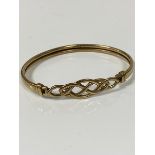 A 9ct gold Celtic knot bangle with clip fastening to top (6.5cm x 5cm) (7.74g)