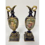 A pair of Vienna porcelain miniature ewers decorated with oval vignettes depicting figures with