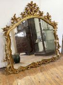 A large rococco style gilt framed wall hanging mirror, the arched frame decorated with conforming
