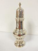 A Chester silver domed sugar castor with pierced top and tapered acorn style finial, raised on